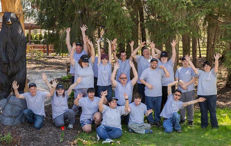 Arc of Allegan members  posing together in a group photo with their hands in the air.