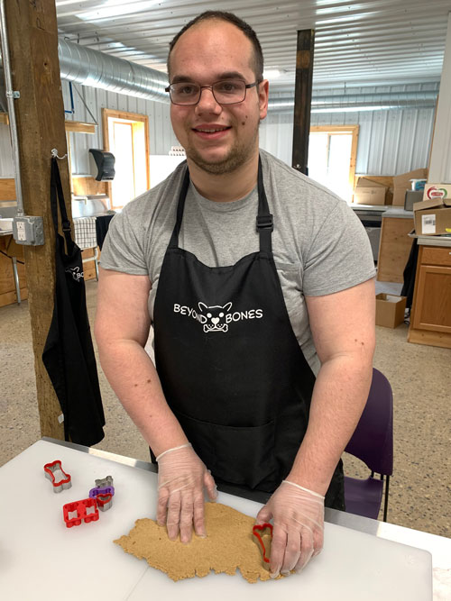 beyond bones employee cutting out dog treats from rolled out dough