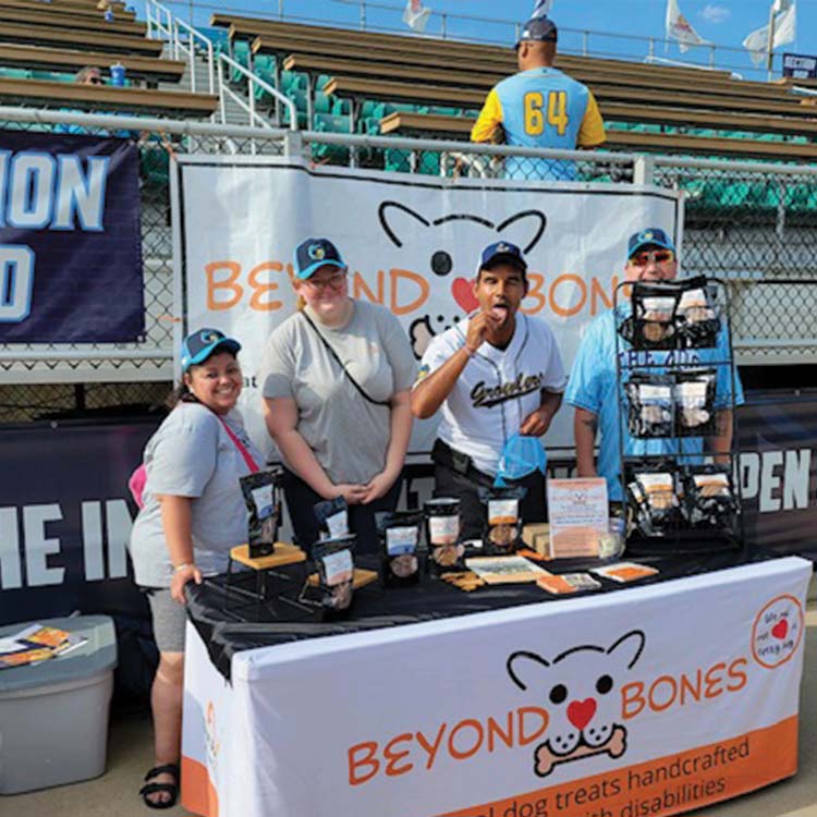 members interact with the public at a growlers game at a beyond bones promotional table